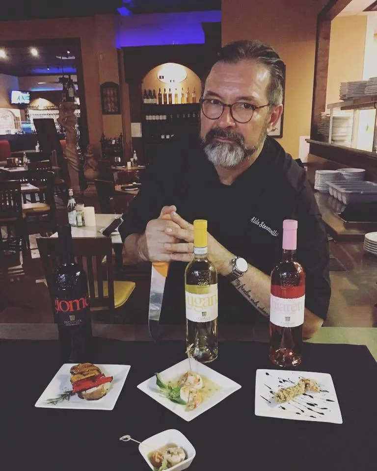 Aldo pouring wine at a tasting